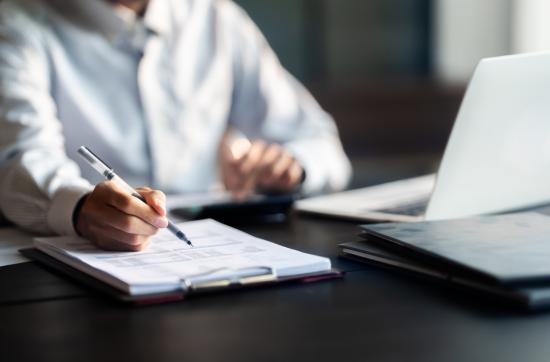 persona en escritorio con ordenador y documento